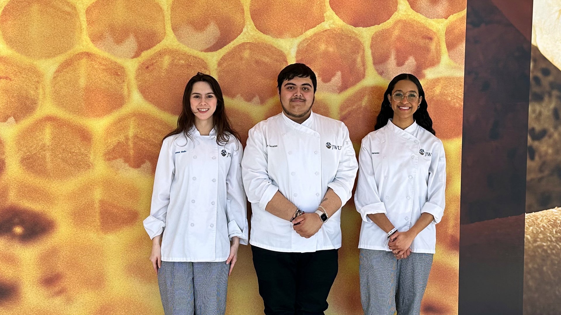 Vanessa Mello, Josue Cervantes and Maru00eda Hernu00e1ndez in the hallway of the Cuisinart Center for Culinary Excellence at JWU Providence.