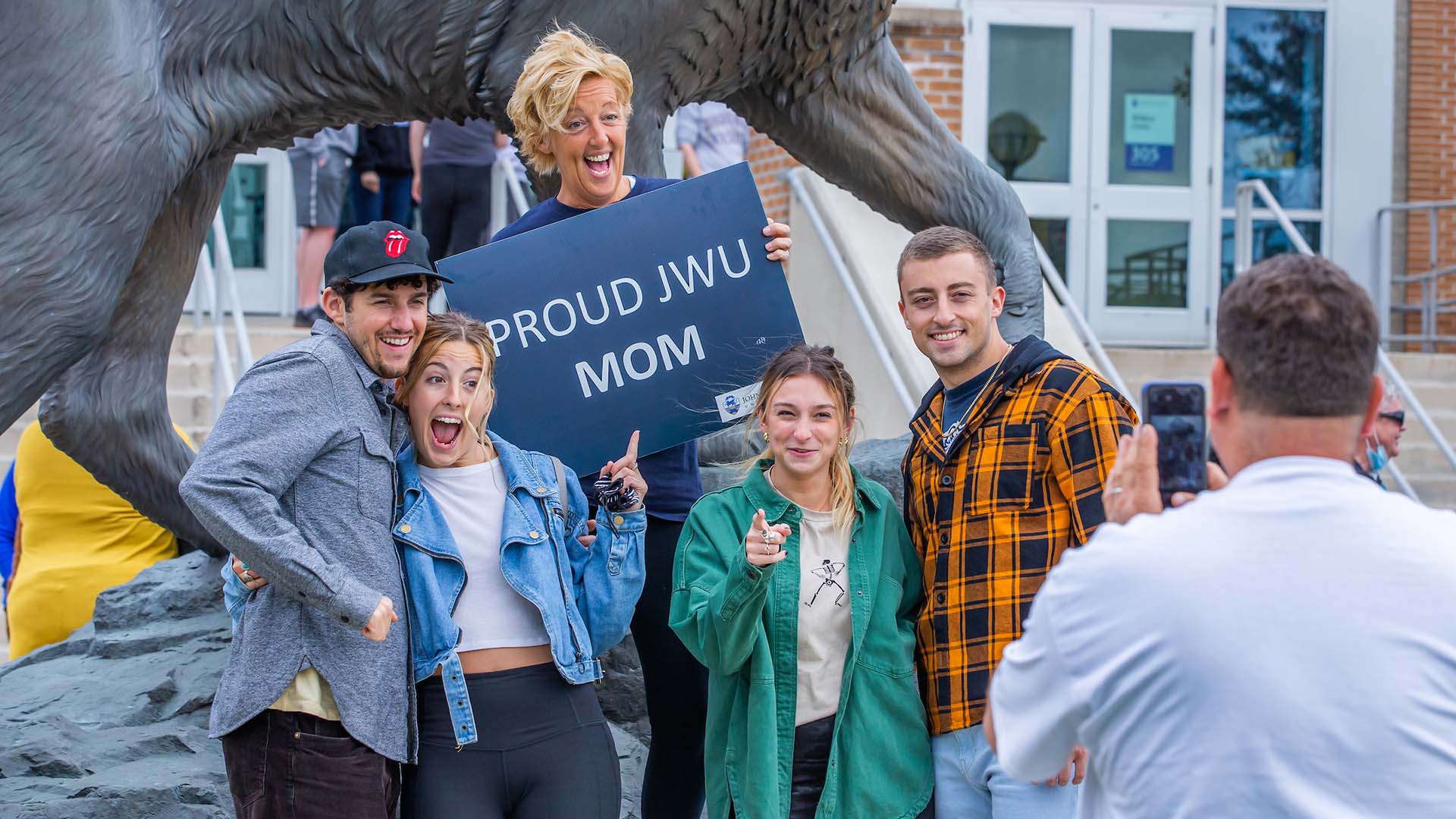 A family posing in front of the Wildcat statue