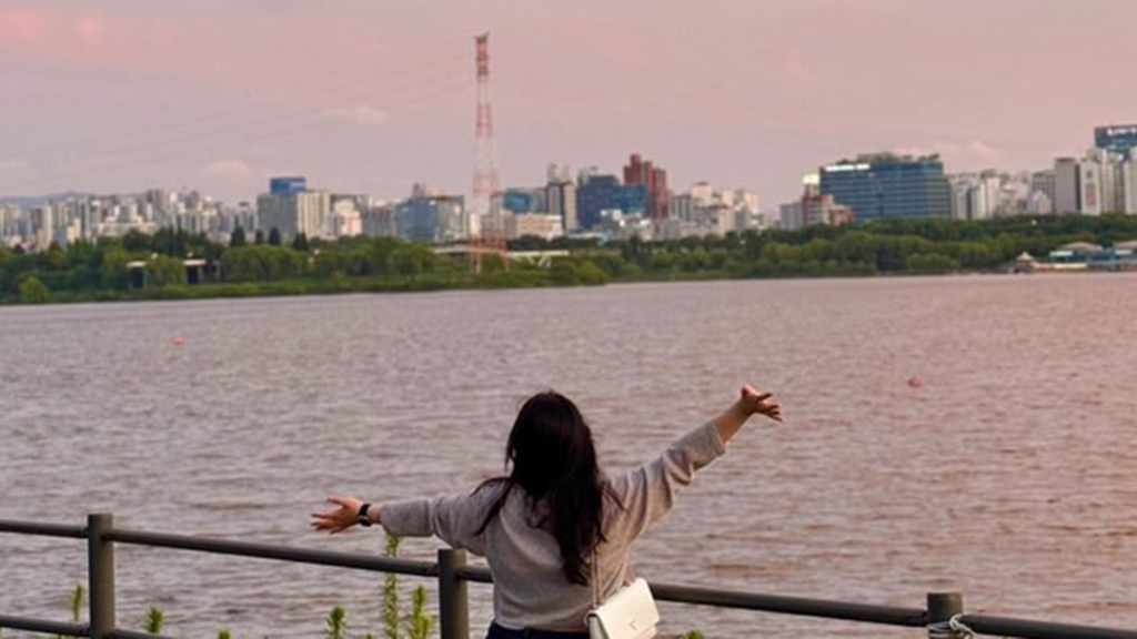 a photo of woman looking at river