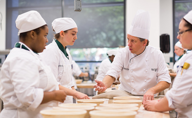 Chef Peemoeller talks to students in a baking lab