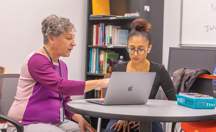 A student sitting with a faculty member as they prepare to enter the job force.