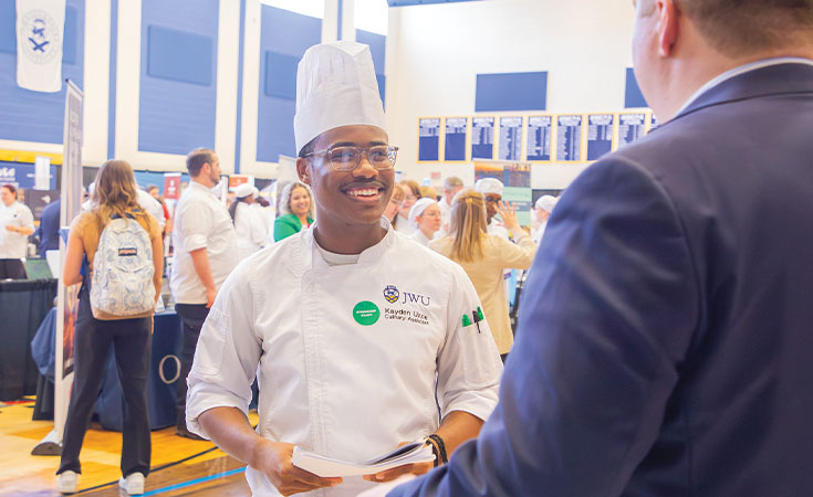 A JWU Charlotte student making connections at a career fair on campus.
