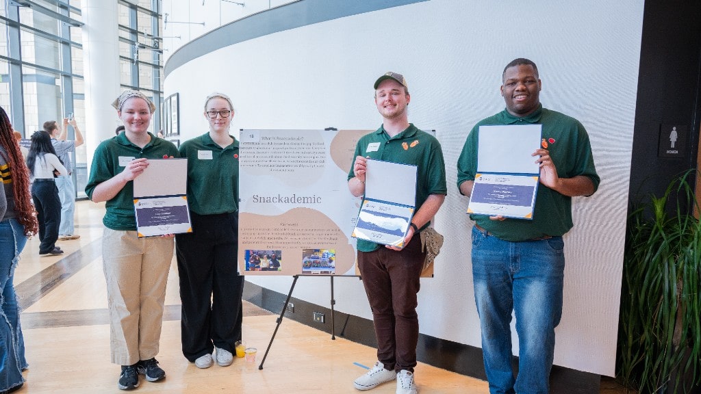 Vanessa Dryer ’25, Lucy Gearhart ’25, Austin Ballard ’25, Xolani Pittman ’25 with their poster presentation for “Snackademic”