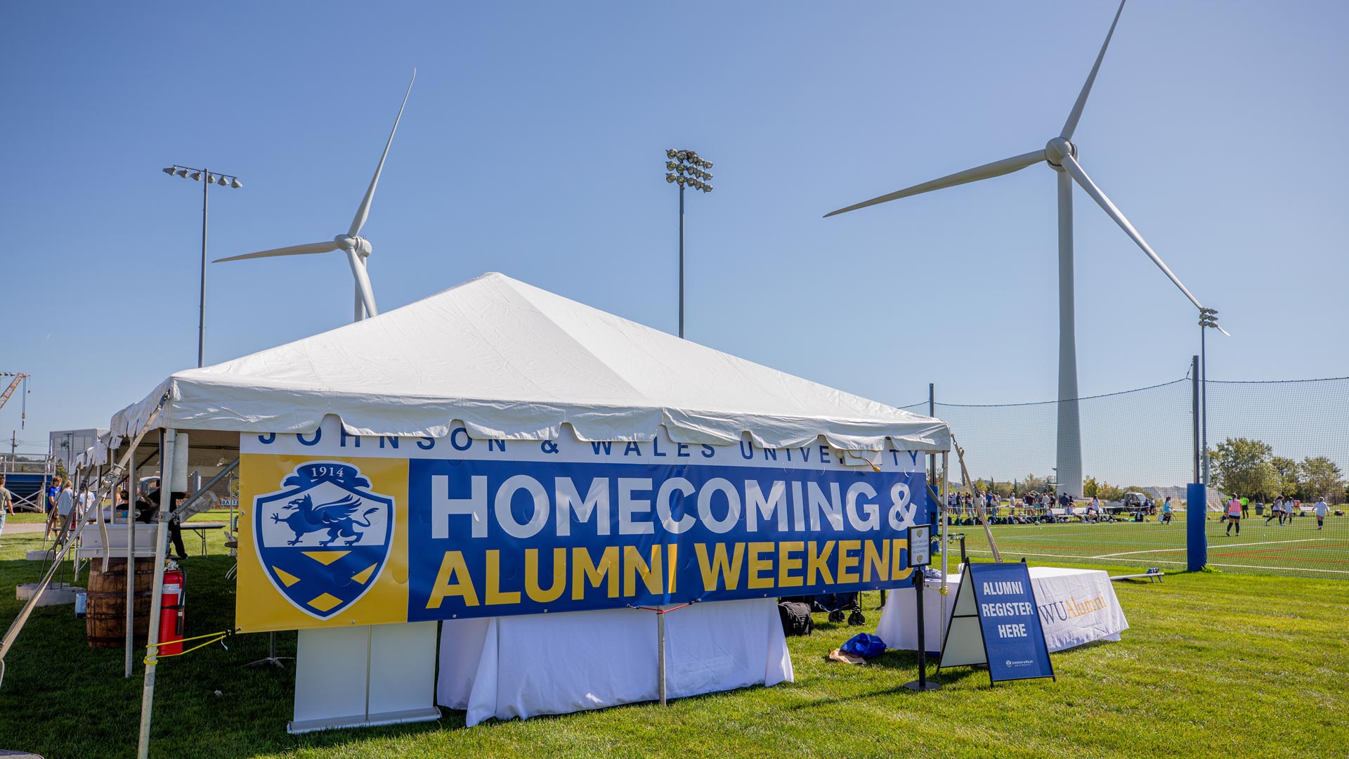 A tent with a banner reading Homecoming u0026 Alumni Weekend