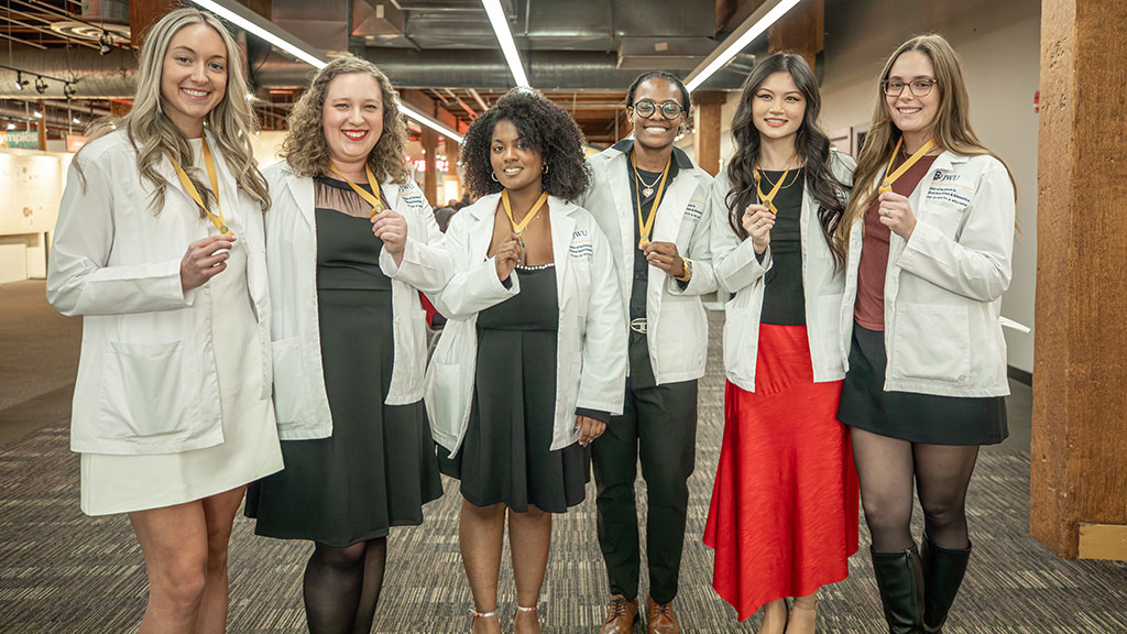 photo of JWU's first graduating MSCND cohort posing together with their pins