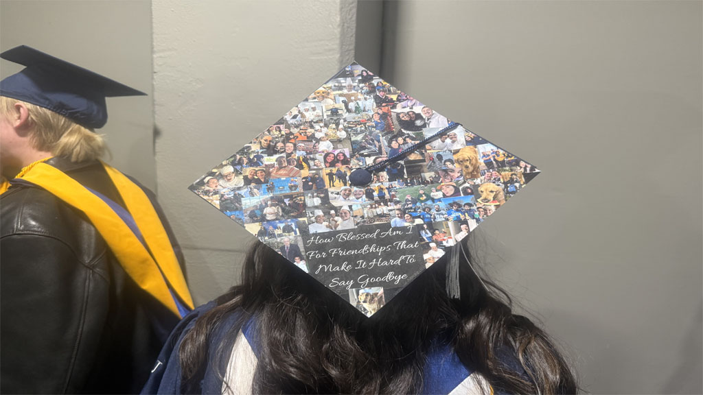 Alia Delacros showing off cap decorated with photos of friends