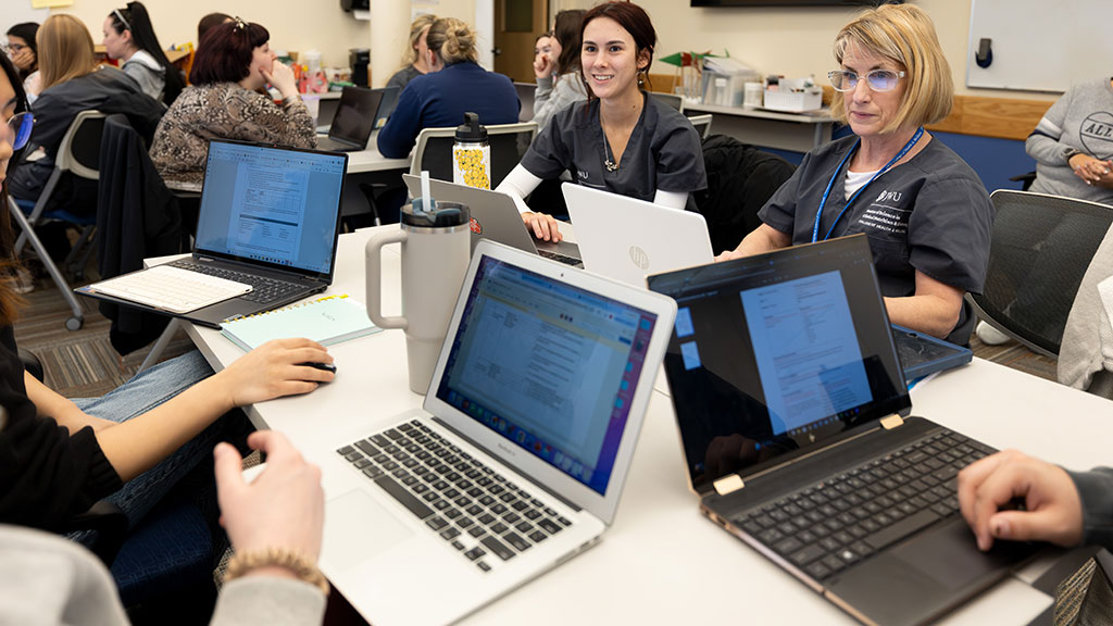 OTD and MSCND students collaborate while at desks with laptops