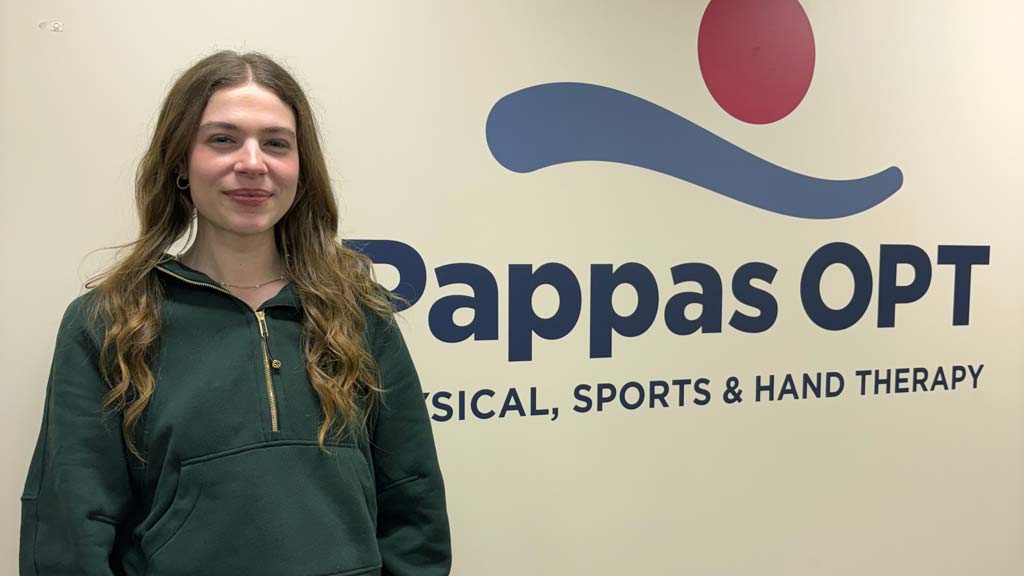 Kerra smiling at the camera with her internship name behind her, Pappas OPT Physical, Sports & Hand Therapy