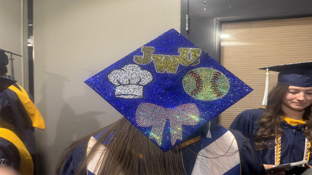 Jilian Reed showing off softball and baking themed grad cap
