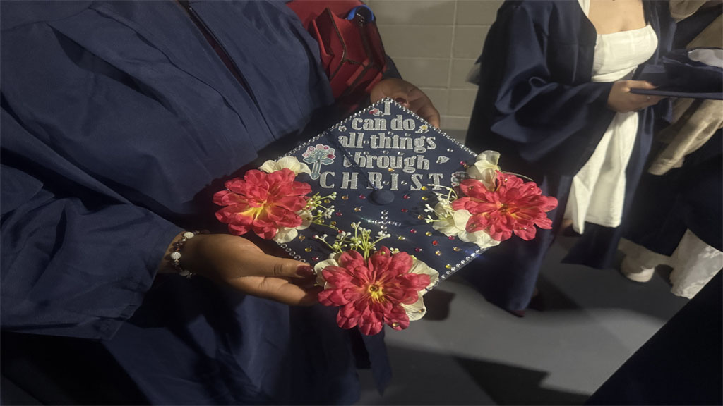 Keisha Collins showing religious scripture decorated grad cap