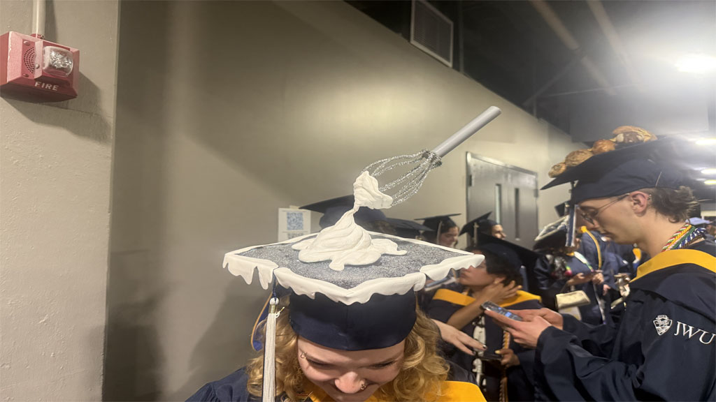 Shannon Burns showing whip and whisk sculpture grad cap