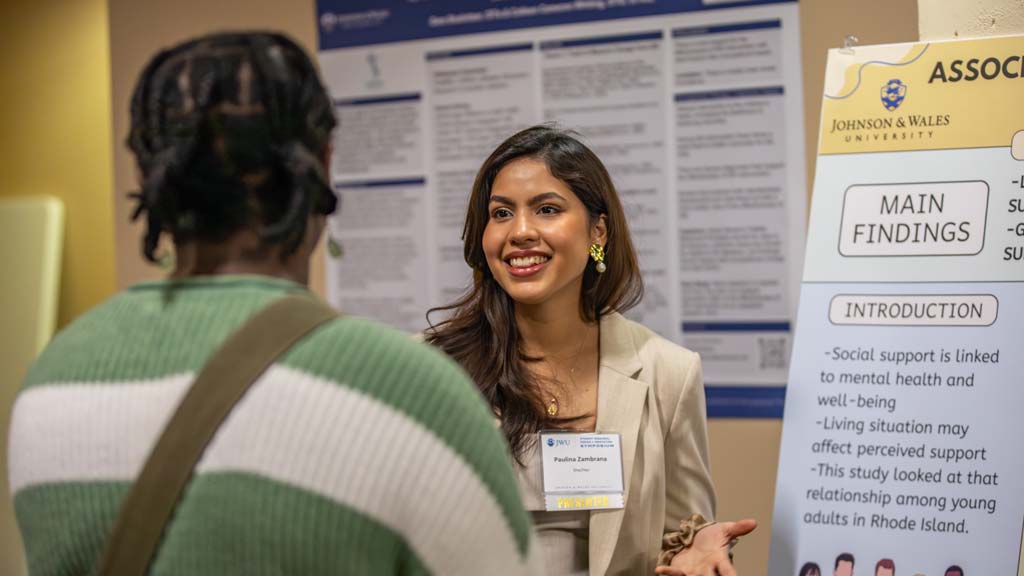 A student presenting their research to people