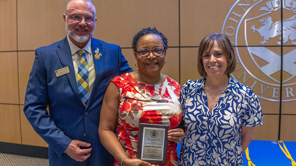 photo of David Hudson awarding a plaque to an education partner