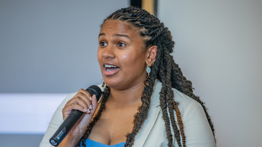 Laila Martin '26 speaks in a microphone at her ABSN pinning