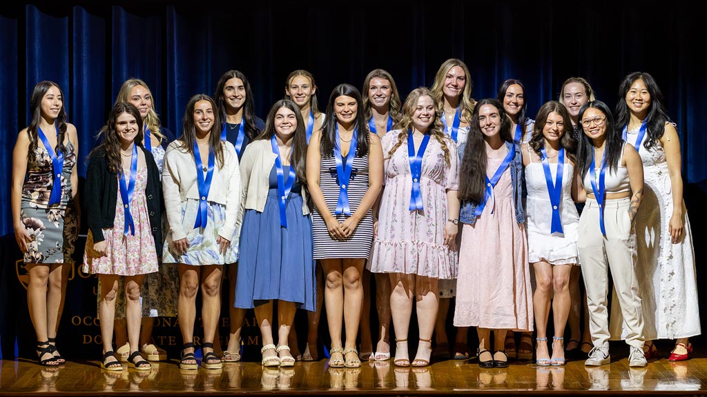 JWU's OTD Class of 2027 pose together at their pinning ceremony