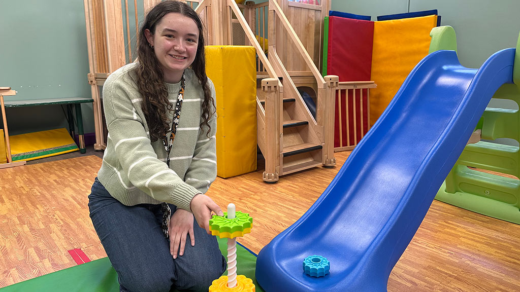 Riley Filiatreault poses in a playroom at J. Arthur Trudeau Memorial Center