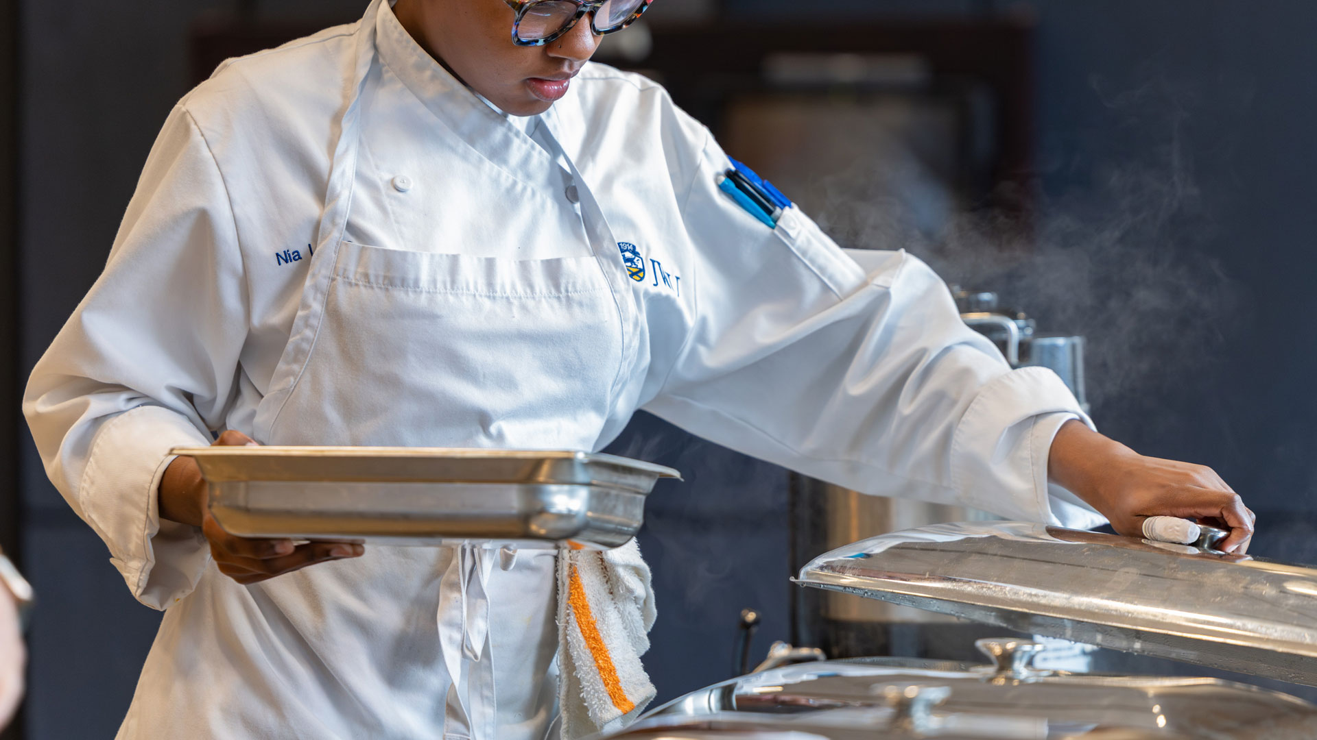 A JWU Charlotte student works the buffet line at a dinner event.