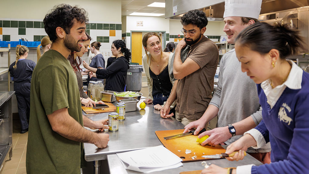 Brown medical students slice lemons in a culinary lab