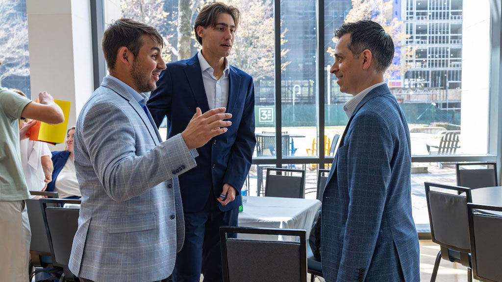 John Billinis (left) chats with colleagues at the JWU Charlotte Connect Conference.